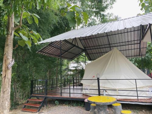 a tent under a canopy next to a tree at NP โฮมสเตย์ นอนเต็นท์ติดแอร์ in Ban Kaeng Manao