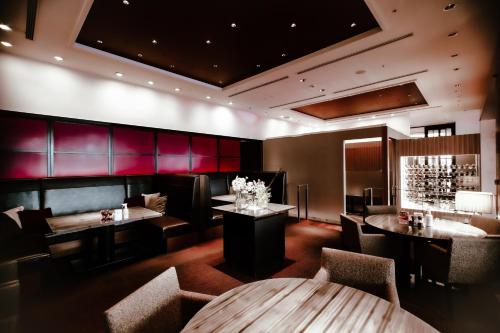 a restaurant with wooden tables and chairs and red walls at Oarks Canal Park Hotel Toyama in Toyama