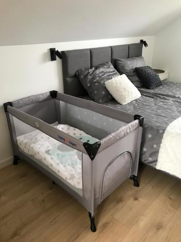 a baby crib in a bedroom next to a bed at Domy na Roztoczu Aleja Lipowa Dom F in Zwierzyniec
