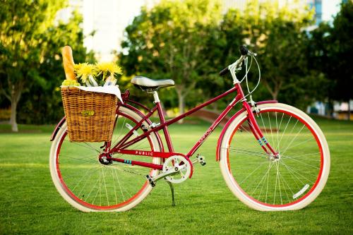a red bike parked on the grass with a basket with flowers at Kimpton - St Honoré Paris by IHG in Paris
