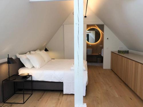 1 dormitorio con cama blanca y mesa en Het Wagenhuis, en Loon op Zand