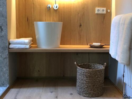 baño con encimera con balde en un estante en Het Wagenhuis, en Loon op Zand