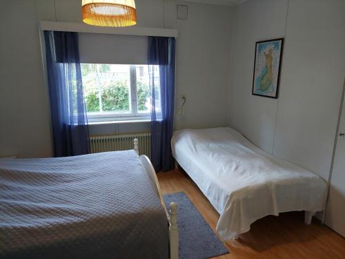 a bedroom with two beds and a window at Punavilla majoitus TASANKO in Säkylä