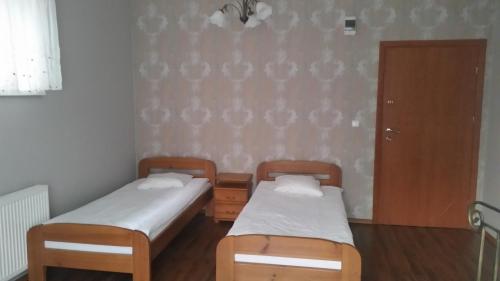 two twin beds in a room with a door at Villa Lena in Gdańsk