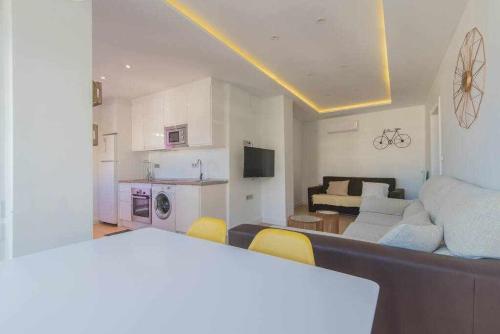a living room with a couch and a kitchen at Precioso apartamento terraza con vistas in Granada