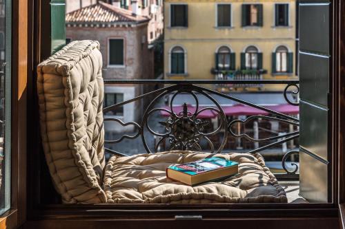 a window with a chair with a book on it at Palazzina Canal in Venice