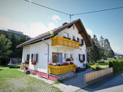 a small white house with a yellow balcony at Beautiful apartment with swimming pool in Tröpolach