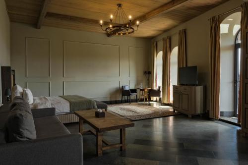 a living room with a couch and a tv at Apricot Hotel Yerevan in Yerevan