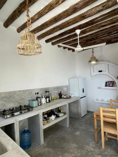 a kitchen with a table and a refrigerator at Olamanga Beach Villa Adults Only in Jambiani