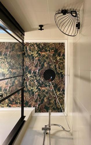 a bathroom with a wall mural with a microphone at Boho style bungalow with ocean view in Mogán