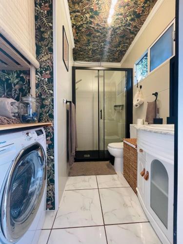 a bathroom with a washing machine and a toilet at Boho style bungalow with ocean view in Mogán