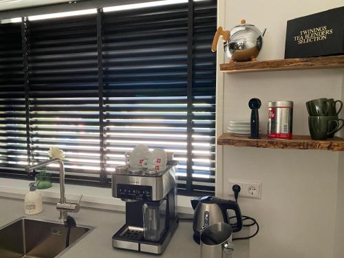 a kitchen counter with a coffee maker on a sink at Holidayhome Geuzenhoeve op de Munnickaij in Schellinkhout