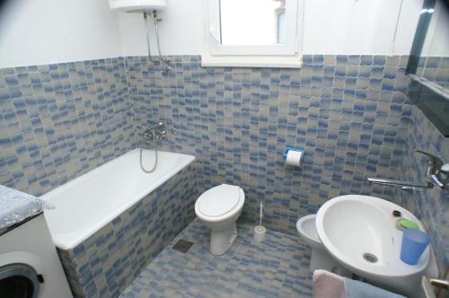 ein Badezimmer mit einer Badewanne, einem WC und einem Waschbecken in der Unterkunft Apartments by the sea Rogoznica - 4313 in Rogoznica