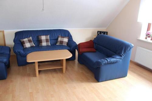 ein Wohnzimmer mit zwei blauen Sofas und einem Stuhl in der Unterkunft Ferienwohnung Höpken 