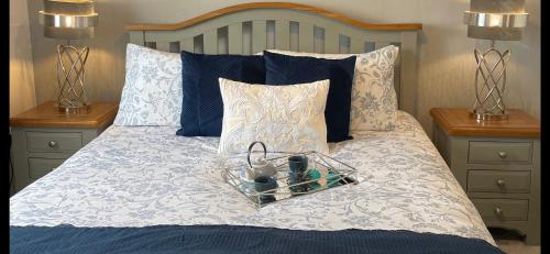 a bed with a tray on it with two night stands at Stylish Scottish House with garden & parking in Perth