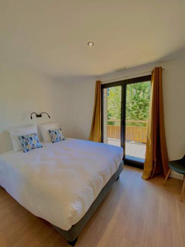 une chambre avec un grand lit et une grande fenêtre dans l'établissement Gîte Lomegaja 10 personnes proche Lascaux et Sarlat, à La Chapelle-Aubareil