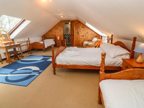 a attic bedroom with two beds and a window at Barn Cottage in Penzance