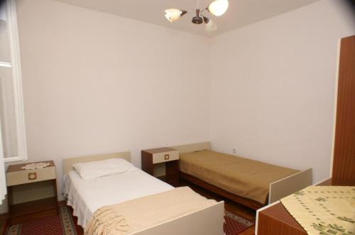 Kleines Zimmer mit 2 Betten und einem Tisch in der Unterkunft Apartments by the sea Vrgada, Biograd - 4206 in Biograd na Moru
