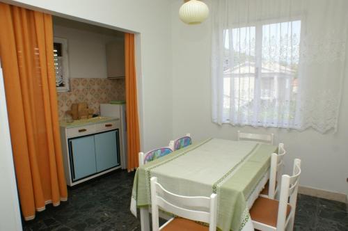 uma pequena cozinha com mesa e cadeiras e uma janela em Apartments by the sea Vrgada, Biograd - 4206 em Biograd na Moru