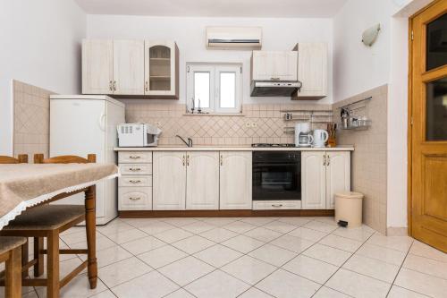 - une cuisine avec des appareils électroménagers blancs et une table dans l'établissement Apartments by the sea Grebastica, Sibenik - 4254, à Šibenik