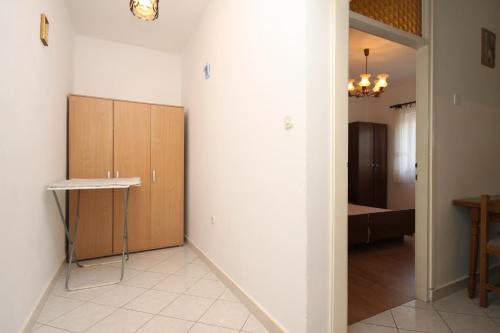 Cette chambre dispose d'un couloir avec une table et des armoires. dans l'établissement Apartments by the sea Grebastica, Sibenik - 4254, à Šibenik