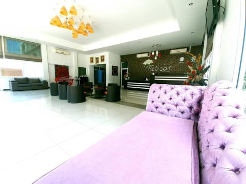 a purple couch in a room with a lobby at Retreat Resort Pattaya in Nong Prue