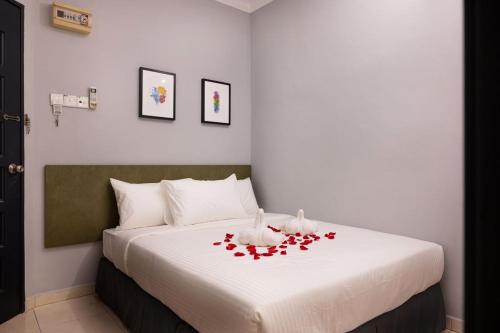 um quarto com uma cama com rosas vermelhas em # Hashtag Hotel - Self Check in em Alor Setar