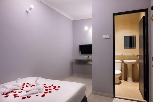 um quarto com uma cama com corações vermelhos em # Hashtag Hotel - Self Check in em Alor Setar