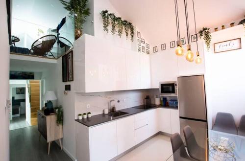 a kitchen with white cabinets and a stainless steel refrigerator at LUXURY PENTHOUSE - River Gallery Art - View&Center in Vila Nova de Gaia