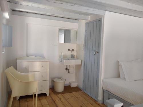 um quarto com uma cama, uma secretária e uma cadeira em Theros Apartments Donoussa em Donoussa