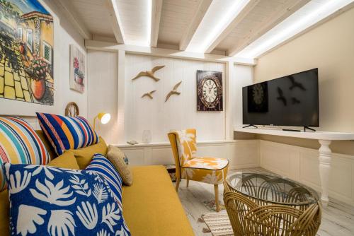 a living room with a couch and a tv at La Casa di Nonna Piera in Giardini Naxos