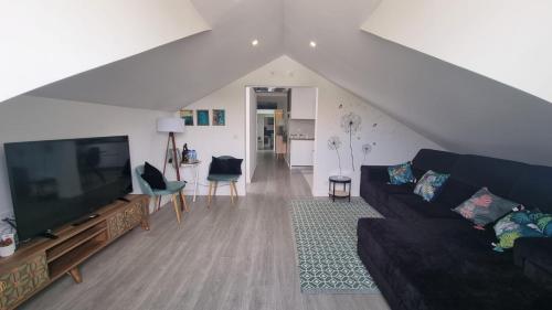 a living room with a couch and a flat screen tv at LUXURY PENTHOUSE - River Gallery Art - View&Center in Vila Nova de Gaia