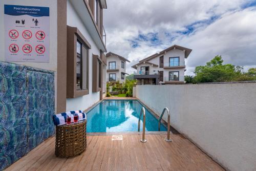 a swimming pool in front of a house at SaffronStays Aster, plunge pool villa with garden, Lonavala in Lonavala