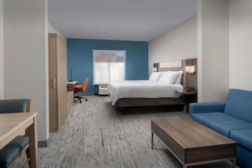 クリントンにあるHoliday Inn Express & Suites Knoxville-Clinton, an IHG Hotelのベッドとソファ付きのホテルルーム