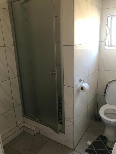 a bathroom with a shower with a toilet at Shamrock Place in Roodepoort