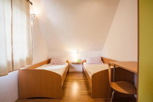 two beds in a small room with a table at House Trta in Ljubljana