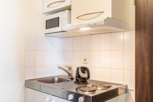 a white stove top oven sitting inside of a kitchen at acora Bochum Living the City in Bochum