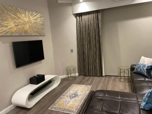 a living room with a couch and a flat screen tv at Stazamaine 1421 in Pretoria