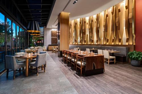 a restaurant with wooden tables and chairs and windows at InterContinental - Washington D.C. - The Wharf by IHG in Washington