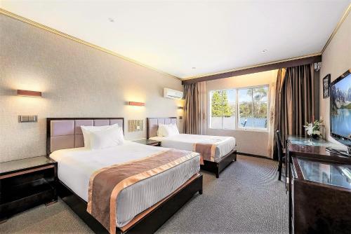 a hotel room with two beds and a large window at Eltham Gateway Hotel & Conference Centre in Eltham