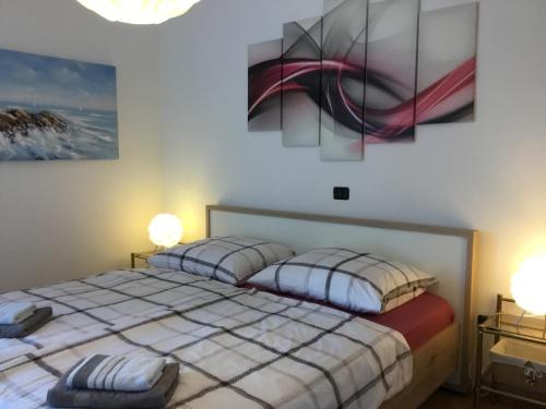 een slaapkamer met 2 bedden en 2 schilderijen aan de muur bij Family-friendly apartments with swimming pool Dvornica, Rogoznica - 11470 in Rogoznica