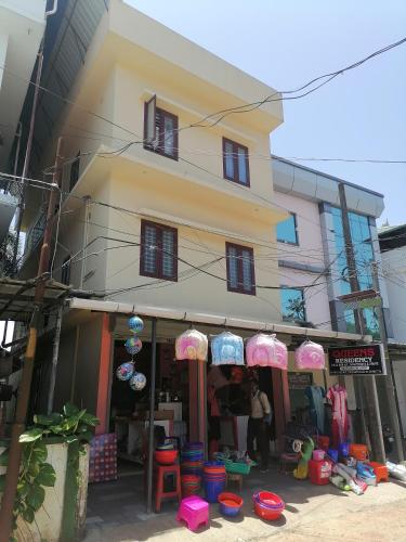 a store with umbrellas in front of a building at Queens Residency in Trichūr
