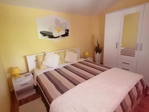 sypialnia z łóżkiem i kwiatem na ścianie w obiekcie Holiday house Dol w mieście Cerovlje