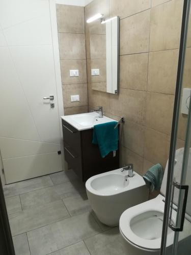 uma casa de banho com um lavatório e um WC em Aero Apartment em Elmas