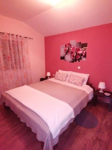 a bedroom with a large white bed with pink walls at Holiday house Dol in Cerovlje
