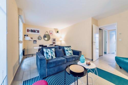a living room with a blue couch and a table at Shopping Center by Plaza - Proche Disneyland Paris in Serris