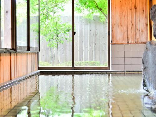 a room with a pool of water in a house at Alpine Route Hotel in Omachi