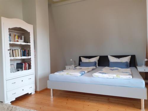 - une chambre avec un lit et une étagère dans l'établissement Ferienwohnung Erika, à Moritzburg