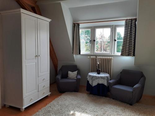 une chambre avec deux chaises, une armoire et une table dans l'établissement Ferienwohnung Erika, à Moritzburg