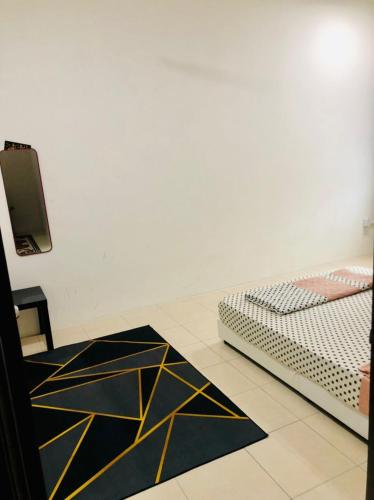 a room with a bed and a black and yellow rug at Homestay Cahaya 1 Seri Iskandar in Seri Iskandar